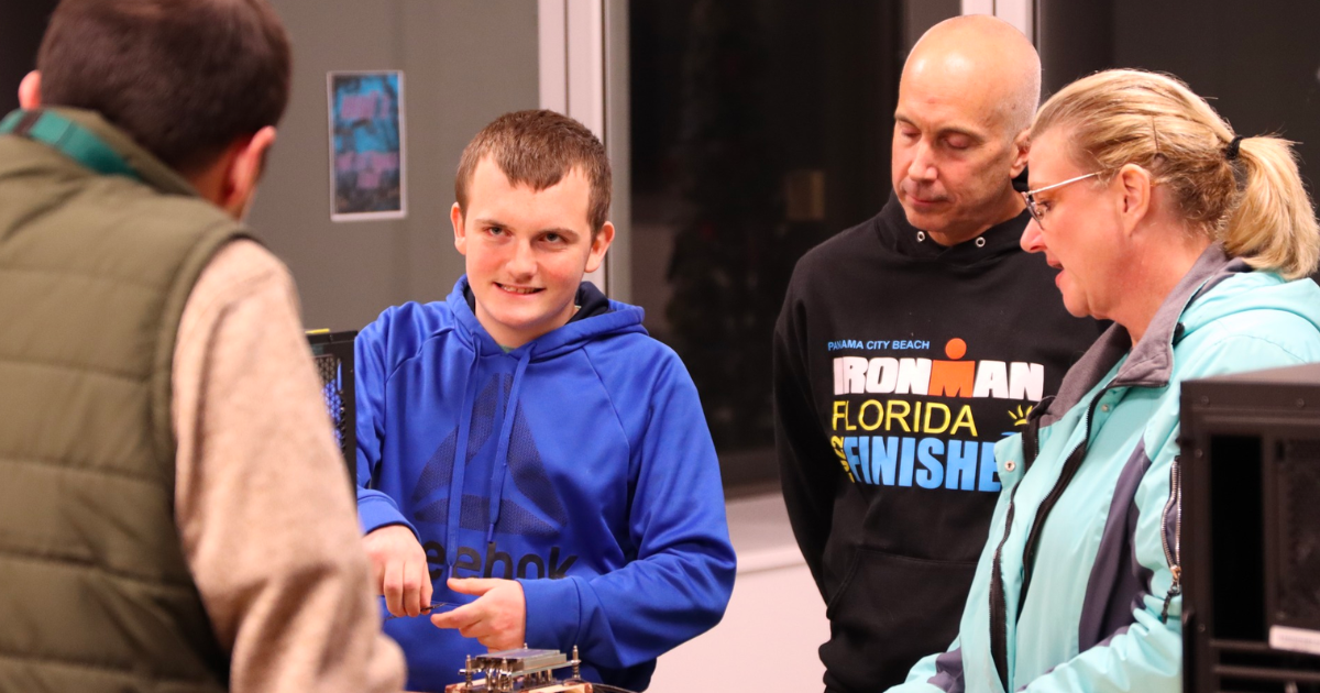 Picture of a student touring LIFT with his parents while speaking to a facilitator Picture of a student touring LIFT with his parents while speaking to a facilitator